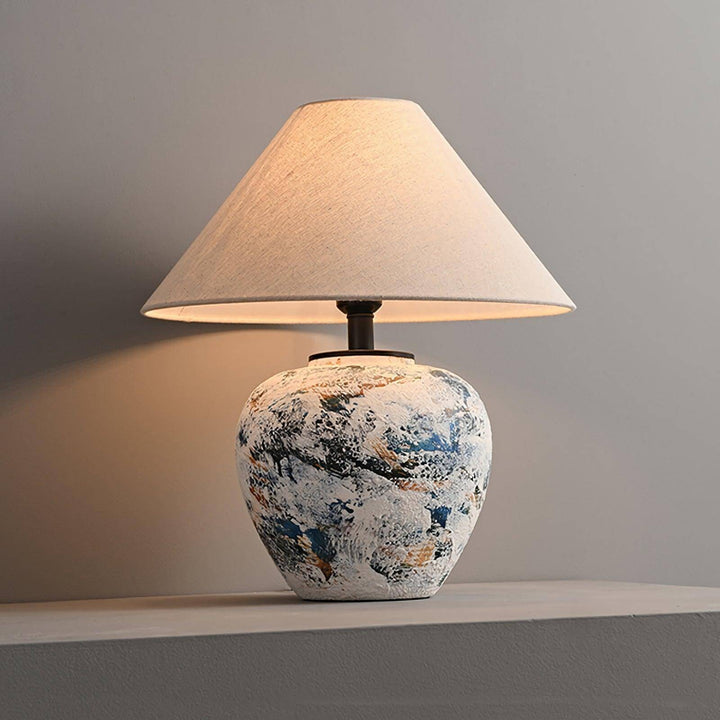 Neoclassical ceramic table lamp with a textured vase design and soft fabric shade, perfect for living room decor.