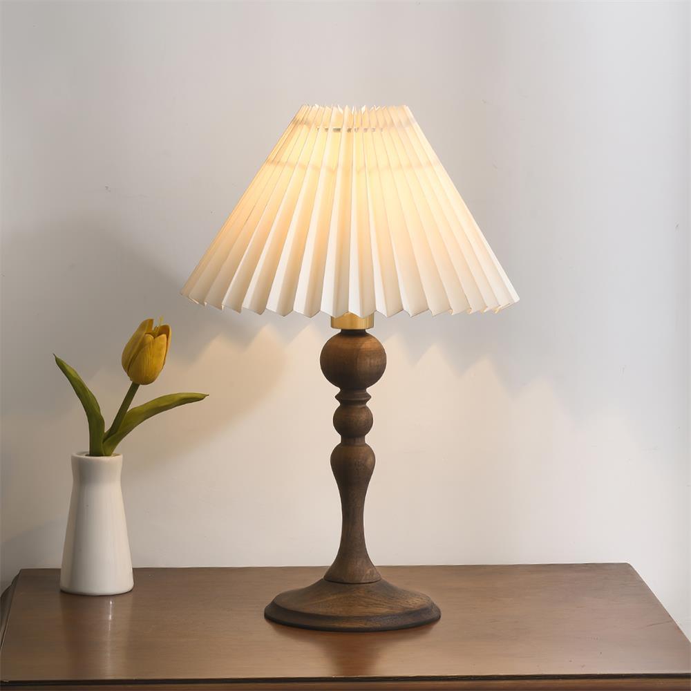 Zulu Pleated Table Lamp with wooden base and pleated white shade on a table; perfect for vintage decor.