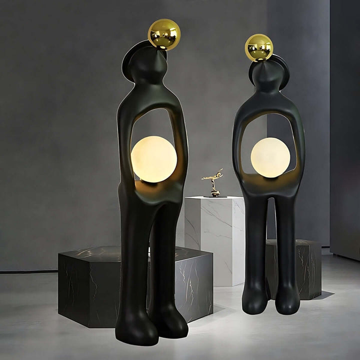 Sculptural resin floor lamp duo with gold accents, adding art deco elegance to living room decor.