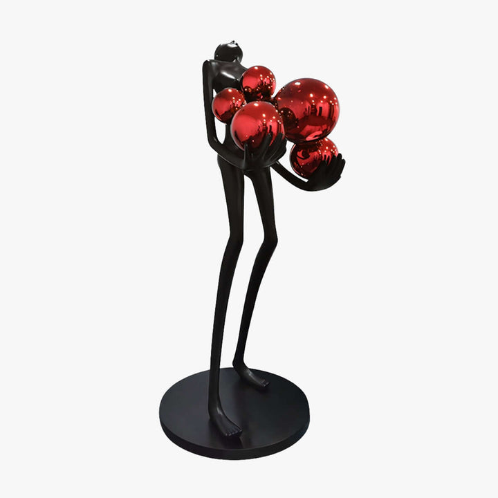 Sculptural floor lamp featuring a black figure holding red orbs, perfect for modern art deco decor.