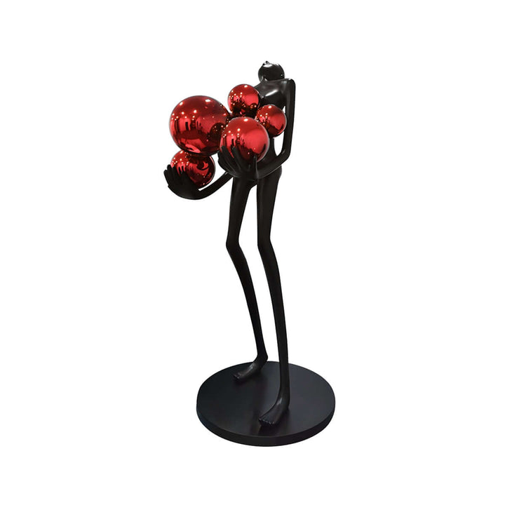 Sculptural floor lamp featuring a black figure holding red decorative spheres, ideal for art deco style interiors.