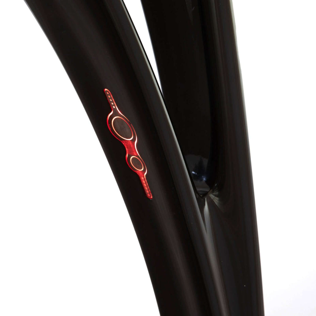 Close-up of a sleek black bicycle frame featuring a vibrant red logo detail.