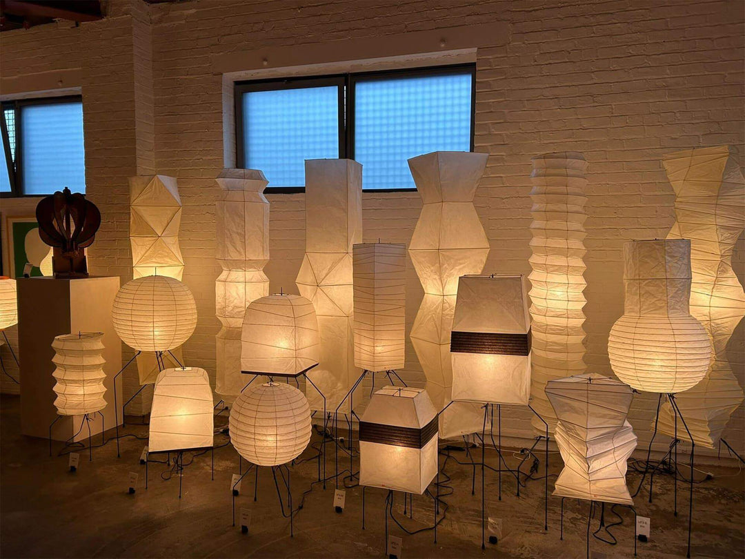 Washi paper floor lamps displayed in a gallery, showcasing decorative tripod designs for stylish living room lighting.