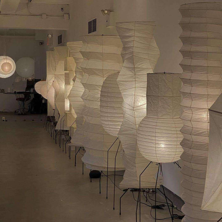 A collection of decorative Japanese paper floor lamps, featuring unique designs and warm light for a stylish living room ambiance.