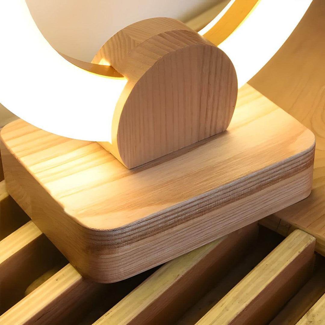 Modern wood table lamp with a round design and warm light, ideal for minimal bedside decor.