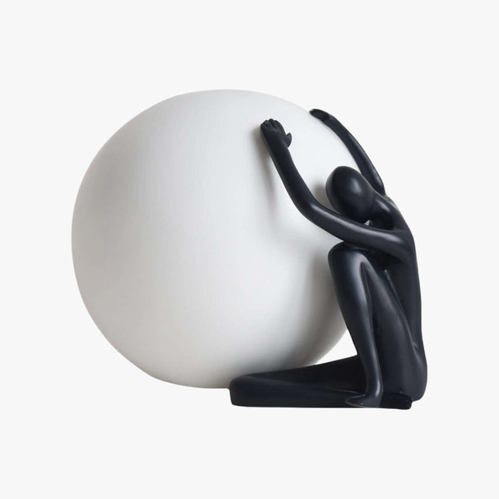 Modern sculpture table lamp featuring a black figure supporting a white orb, perfect for art deco decor.