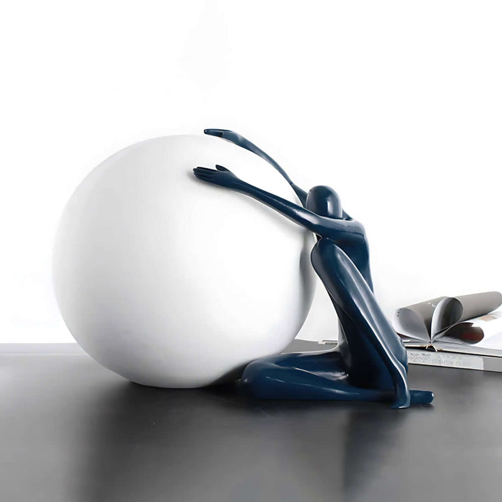 Zelvora sculptural table lamp featuring a blue figure embracing a large white sphere, perfect for modern decor.