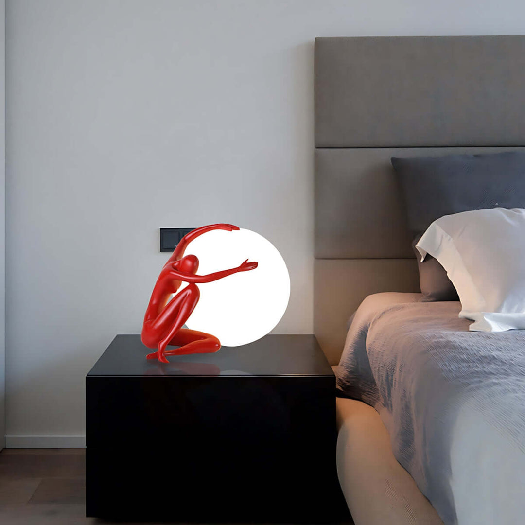 Zelvora sculptural table lamp in red, an art deco lamp illuminating a modern bedroom setting.