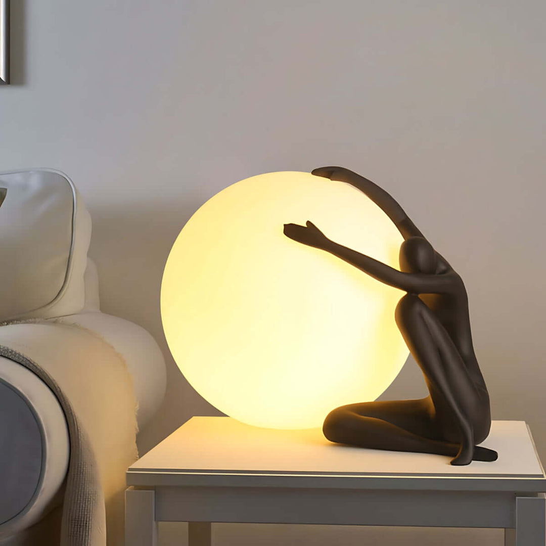 Art deco sculpture table lamp featuring a figure embracing a glowing sphere, perfect for stylish living room lighting.