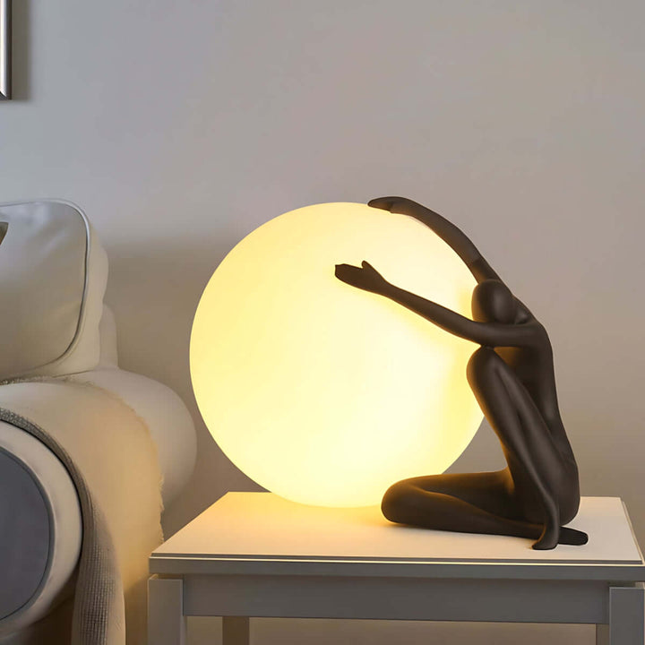 Art deco sculpture table lamp featuring a figure embracing a glowing sphere, perfect for stylish living room lighting.
