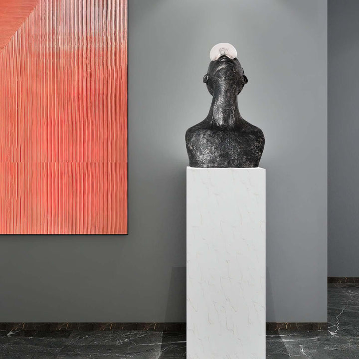 Zoreva resin sculpture displayed on a pedestal in a modern living room with abstract wall art.