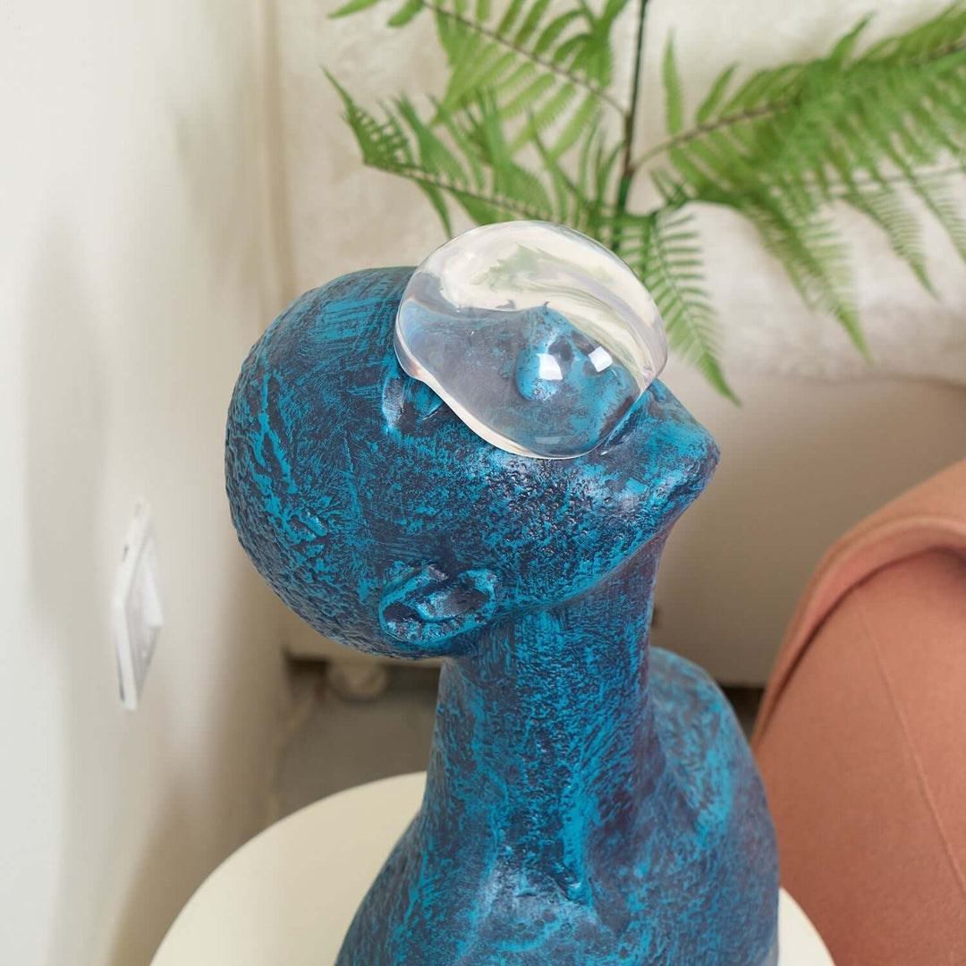Zoreva resin sculpture depicting a blue bust with a glass orb on its head, ideal for living room decor.