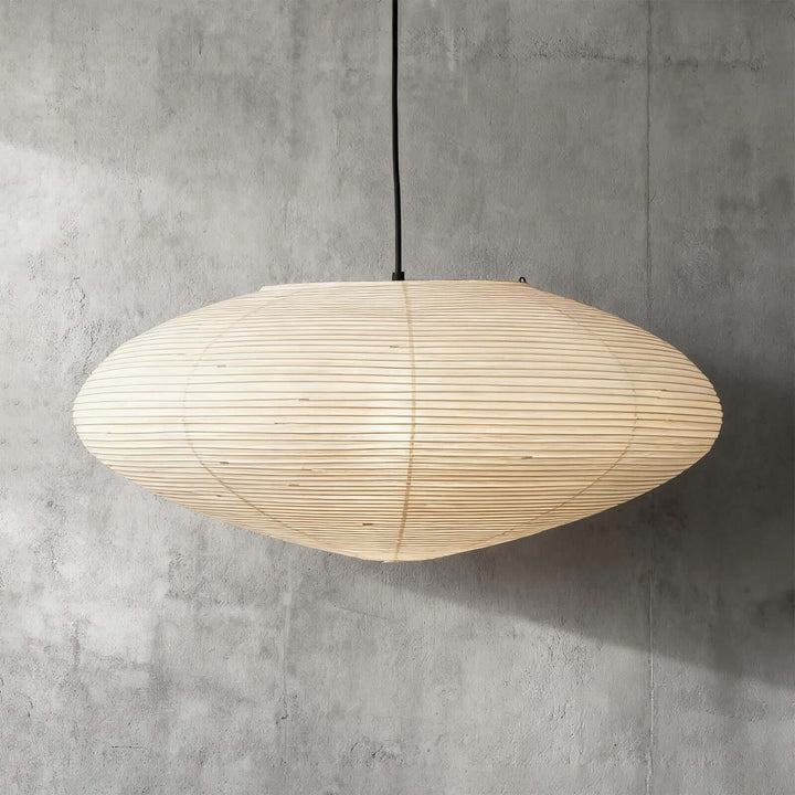 95A washi paper pendant light with a black wire against a gray wall.