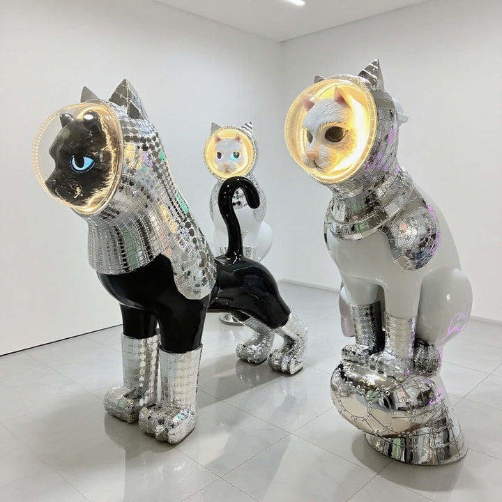 Three sculptural cat figures in shiny disco ball design, showcasing creative art and contemporary style.