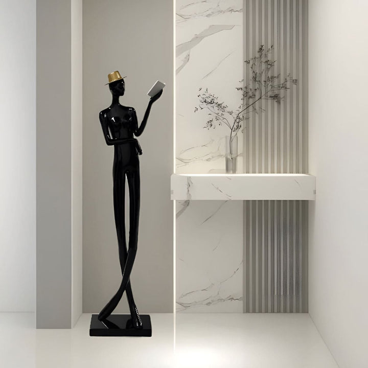 Sculptural floor lamp in art deco style, featuring a black statue of a man reading, perfect for modern living rooms.