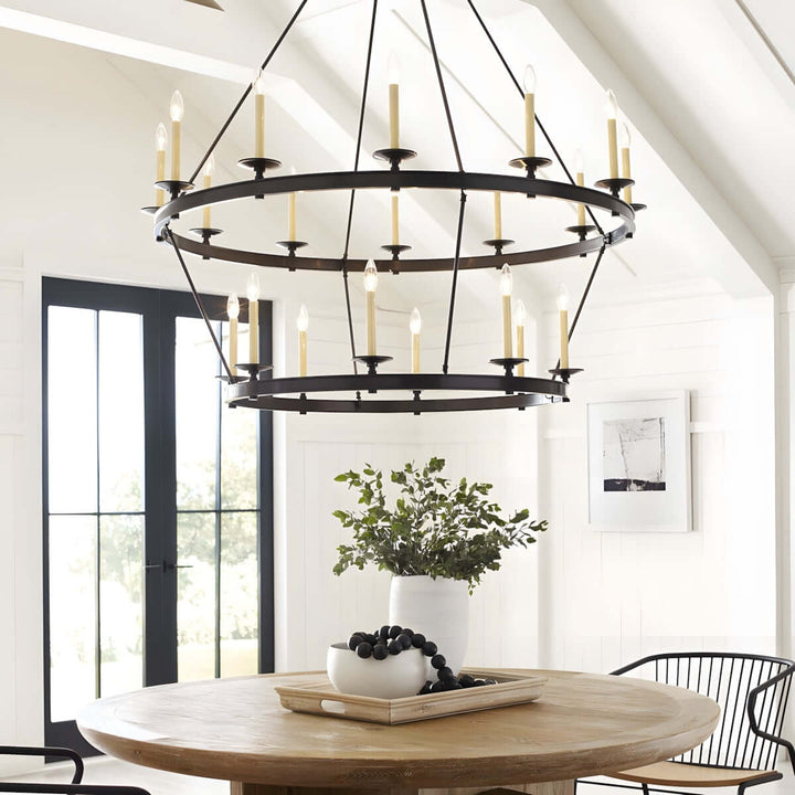 Luvo Serin Chandelier in modern dining room with round table, featuring black and gold finishes and elegant candle-like bulbs.