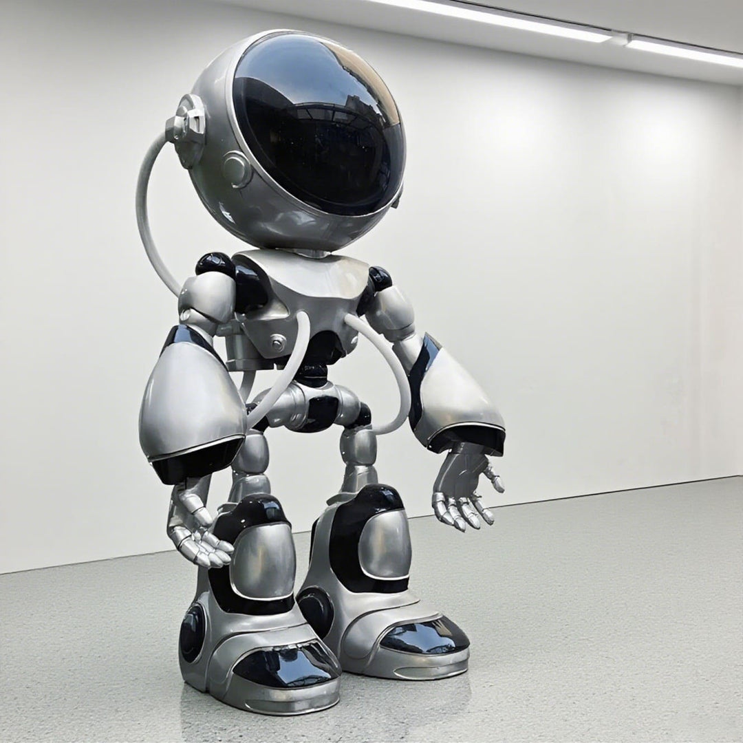 Sculptural silver robot figure with a glossy finish, displayed in a modern gallery setting.