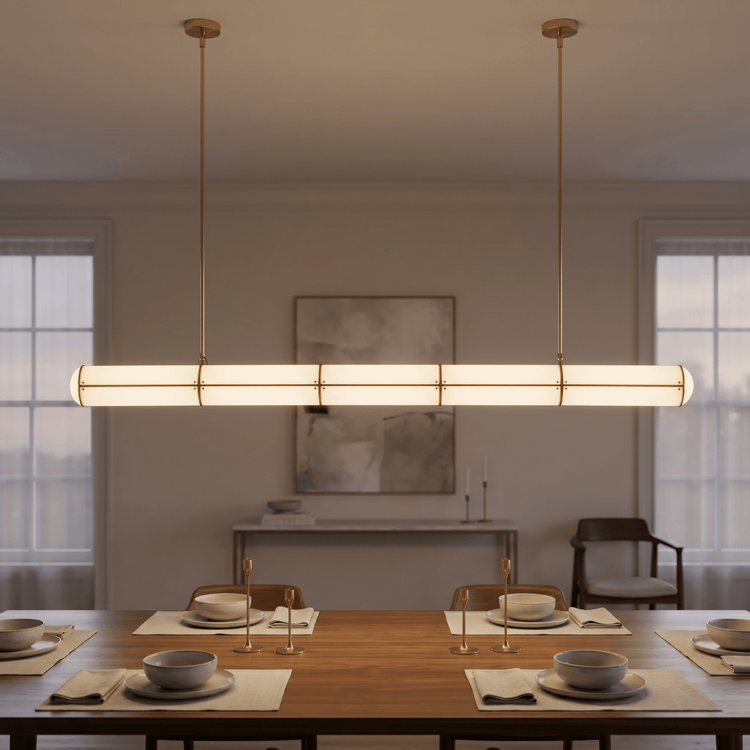 Front view of the brass Acrylic Endless pendant light illuminating a formally set wood dining table