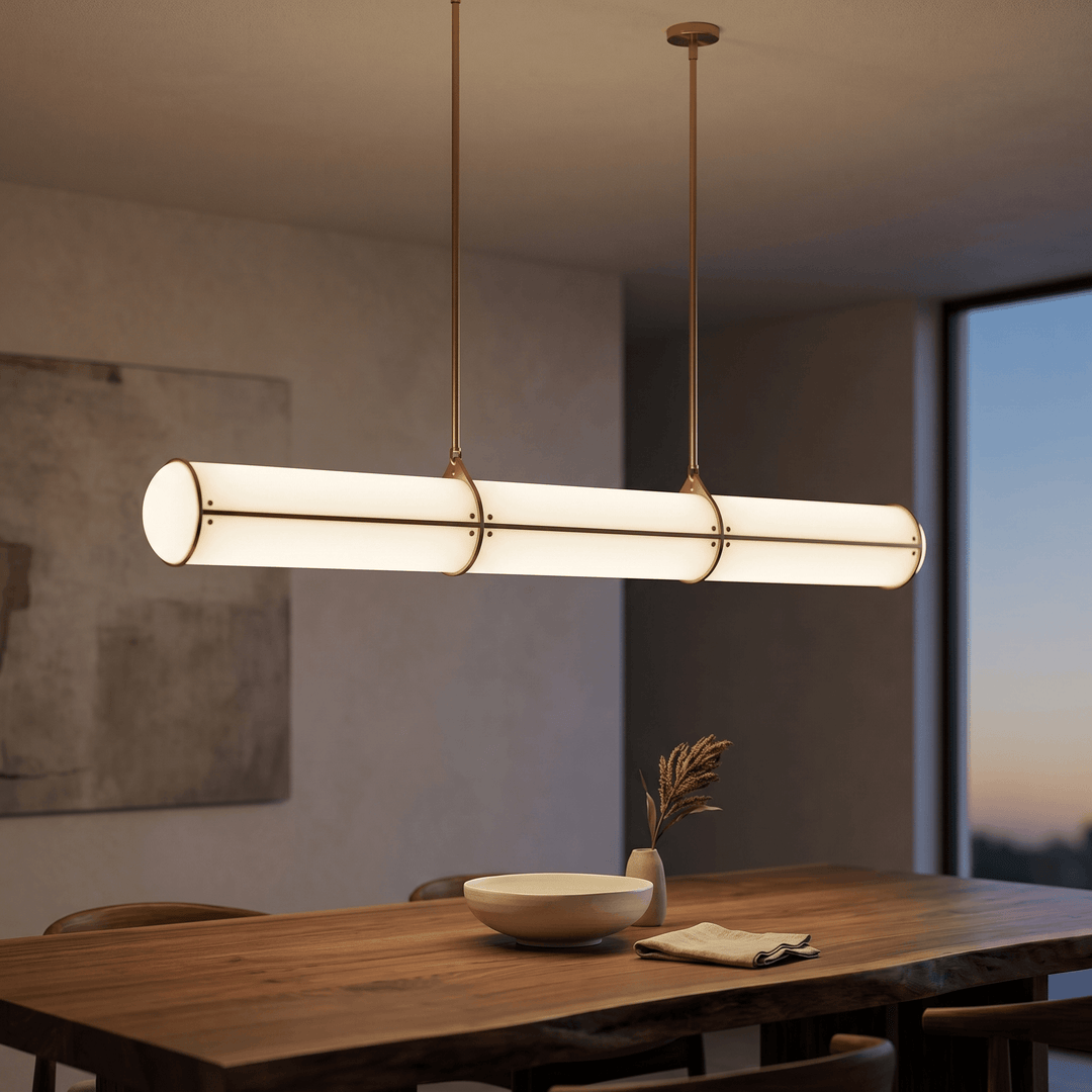 Close angled view of the brass Acrylic Endless pendant light above a wood dining table at dusk