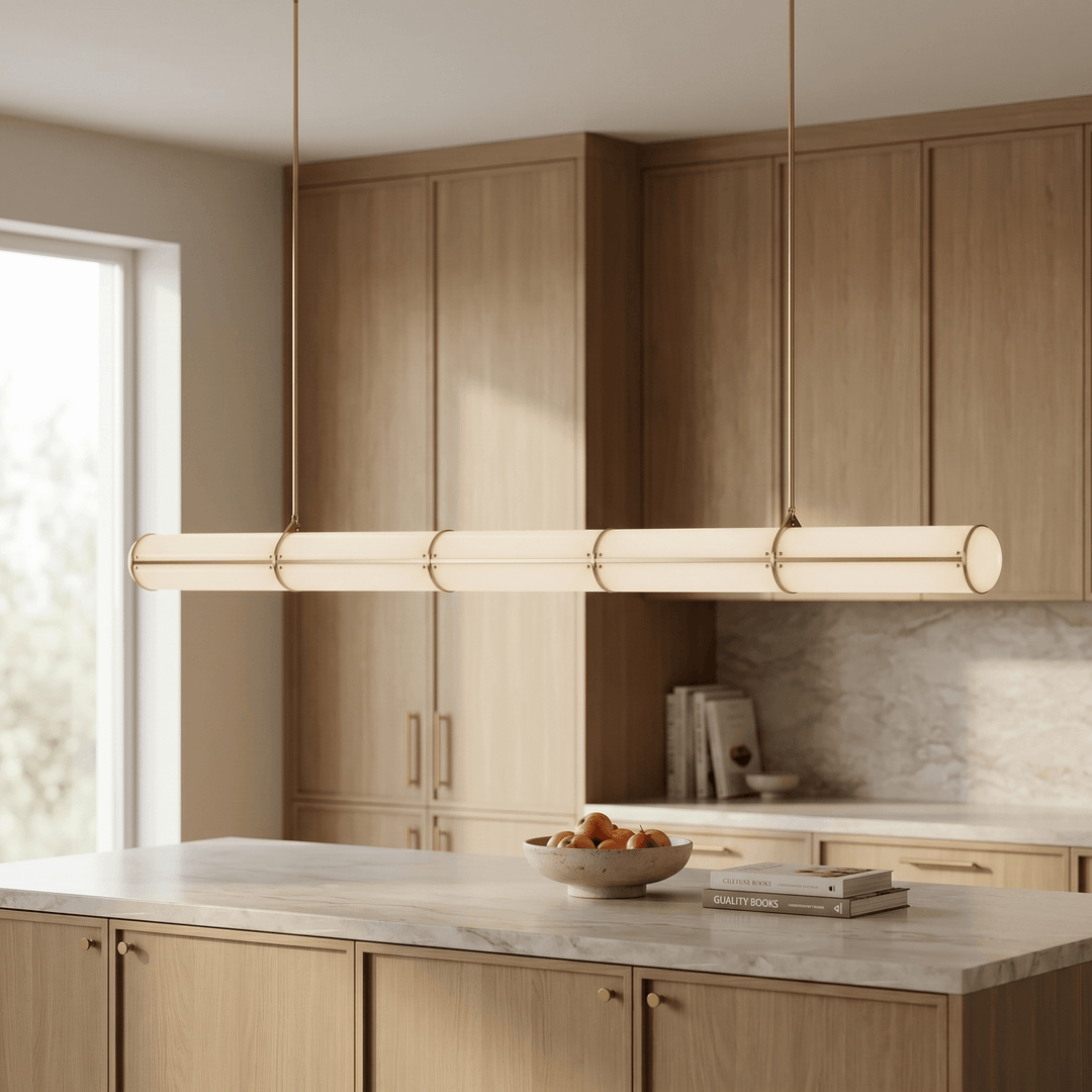 Side view of the brass Acrylic Endless pendant light above a pale wood and marble kitchen island