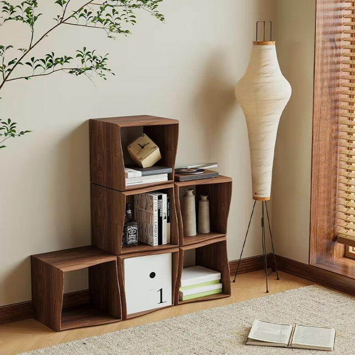 Unlit Akari 14A white paper floor lamp beside modular wood shelving and a window with wood blinds.