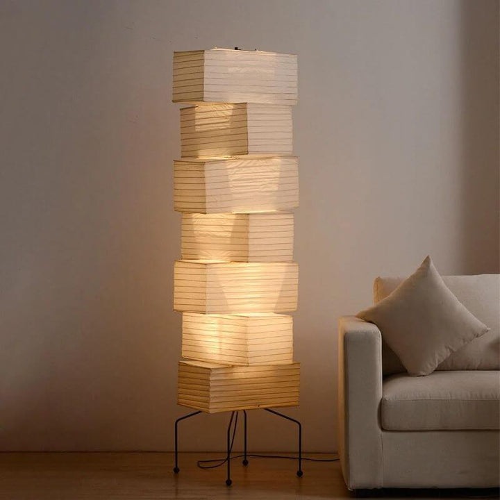 Akari UF4-L10 Japanese-style paper floor lamp glowing softly beside a white sofa
