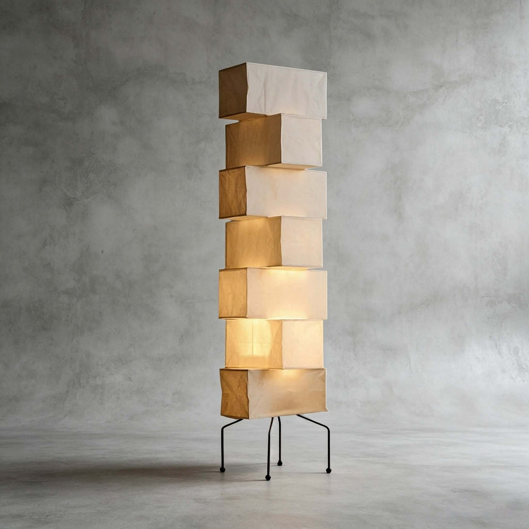 Akari UF4-L10 floor lamp with stacked smooth rice paper shades and a black metal base against a concrete backdrop