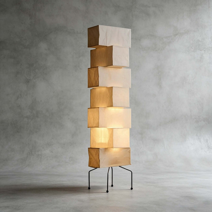 Akari UF4-L10 floor lamp with stacked smooth rice paper shades and a black metal base against a concrete backdrop