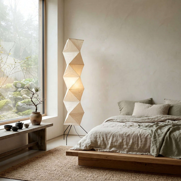 Akari UF4-L8 floor lamp beside a low platform bed and tea table overlooking a garden window