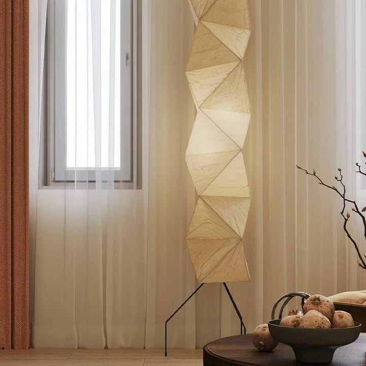 Akari UF4-L8 floor lamp by sheer curtains and a dark wood table in a softly lit interior