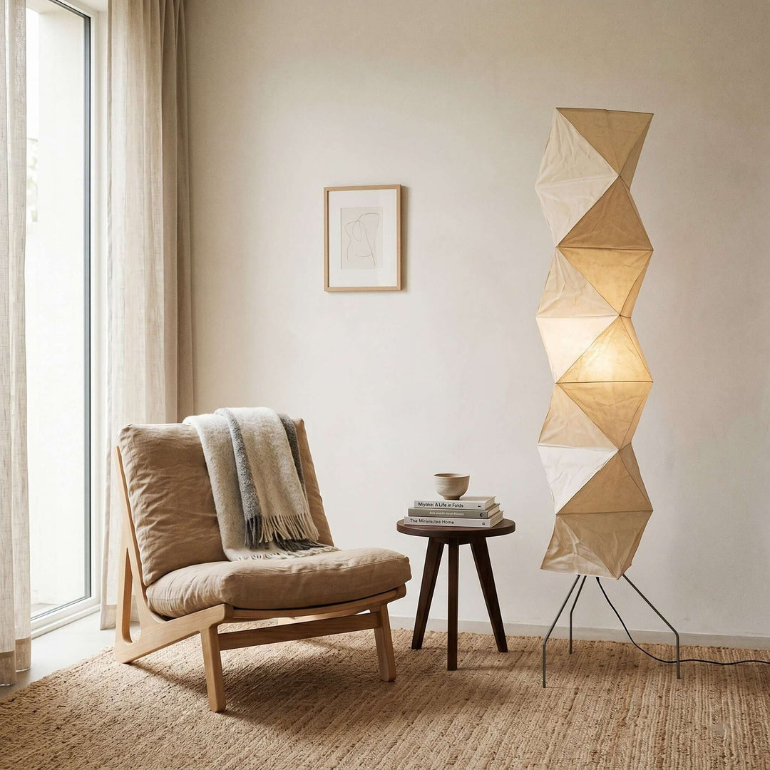Akari UF4-L8 floor lamp beside a cushioned reading chair and books near a tall window
