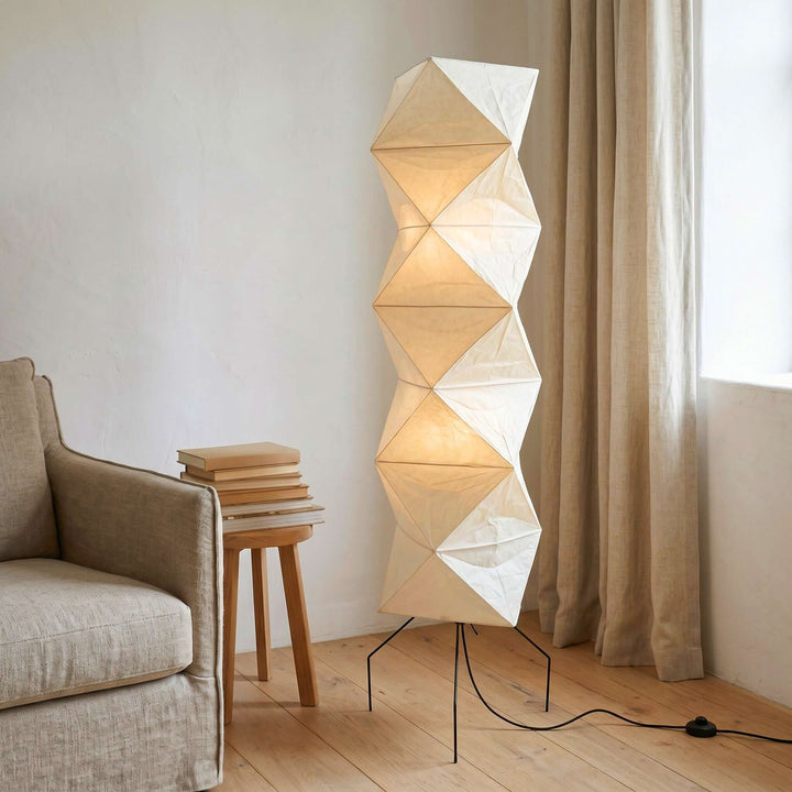 Akari UF4-L8 floor lamp beside a linen sofa and stacked books in a sunlit living room