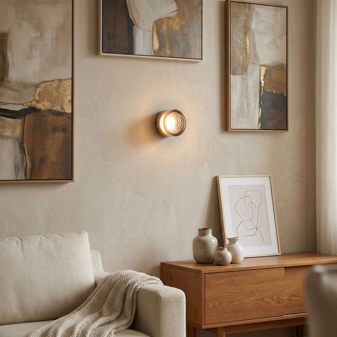 Amber Dimple wall sconce above a wood cabinet in a warm living room.