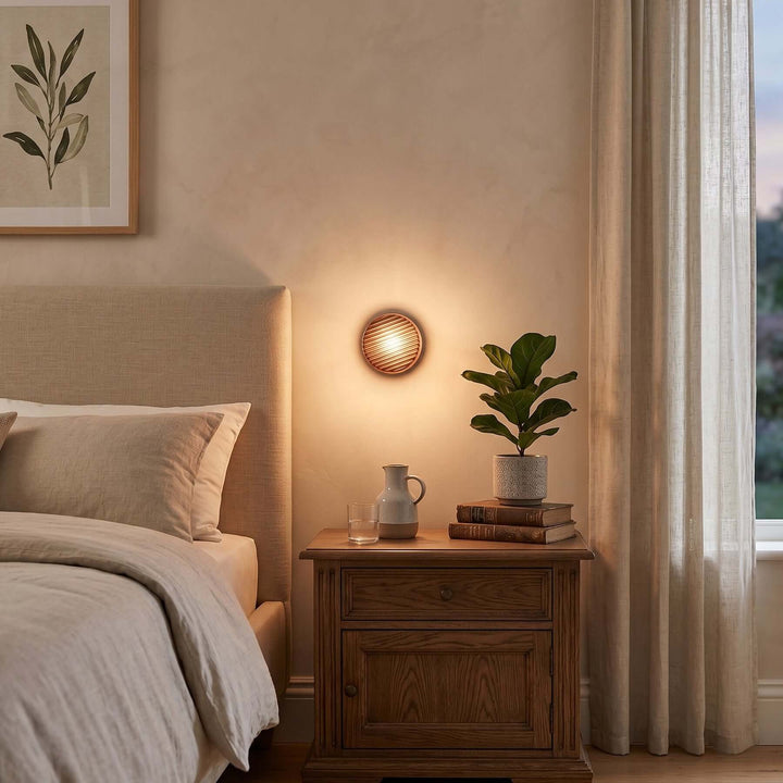 Amber Dimple wall sconce above a wood nightstand in a bedroom.