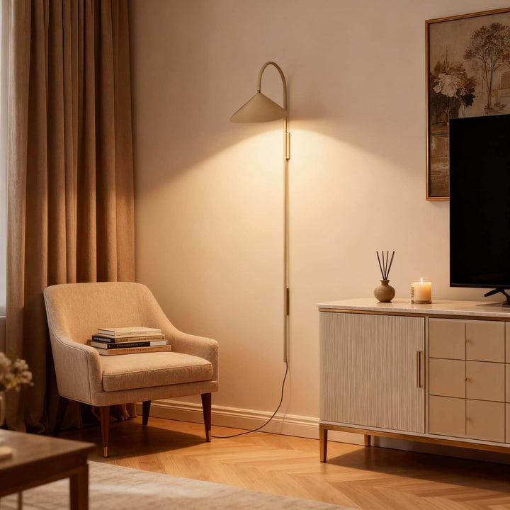Long beige Arum wall sconce beside an armchair and television cabinet in a warm living room