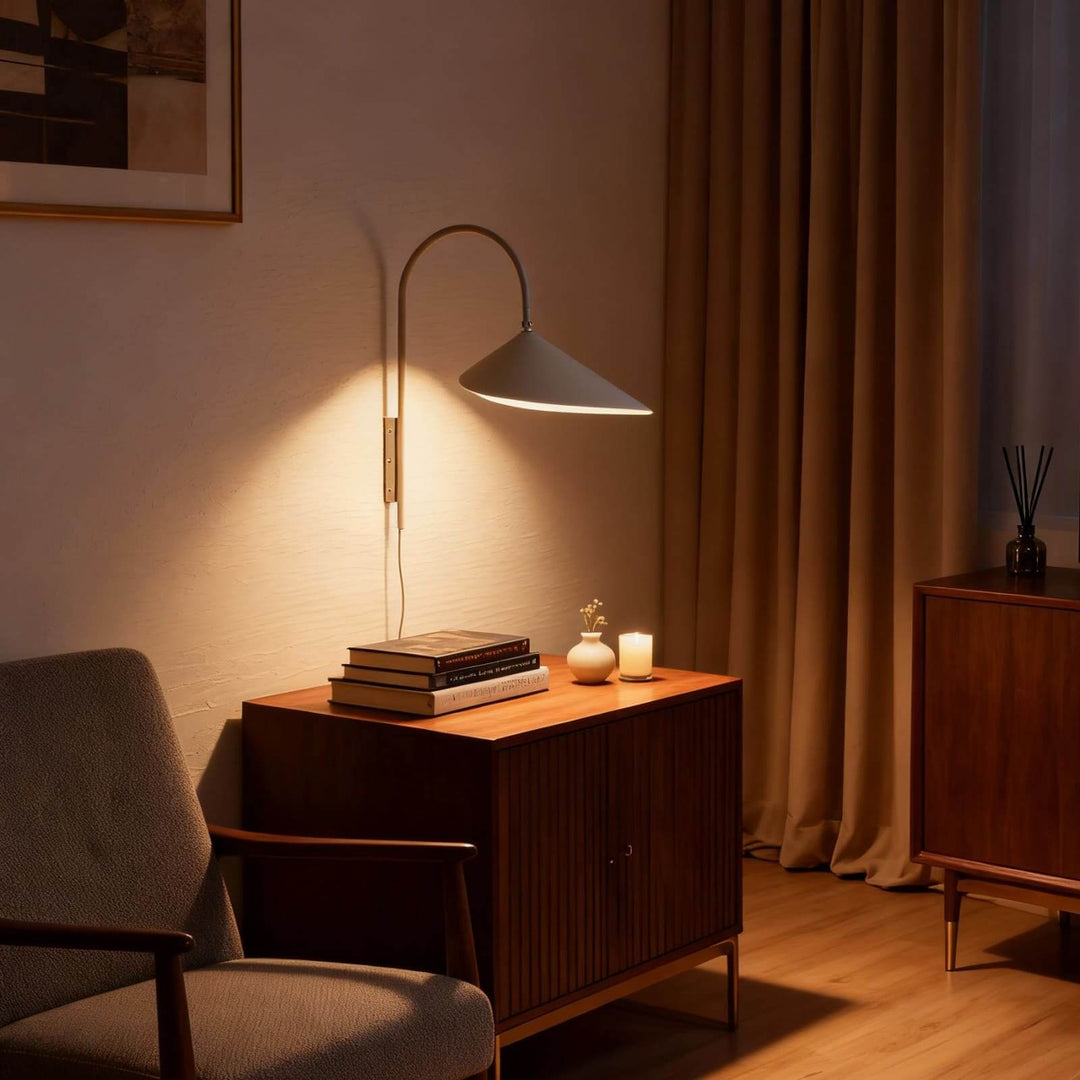 Beige Arum plug-in wall sconce illuminating a wood cabinet in a warm reading corner