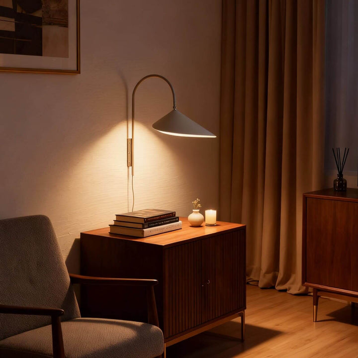 Beige Arum plug-in wall sconce illuminating a wood cabinet in a warm reading corner