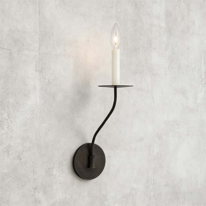 Short black single-light candle wall sconce with curved arm and exposed candelabra bulb