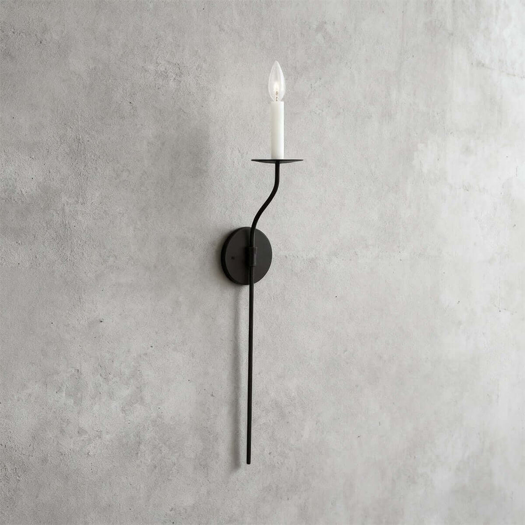 Tall black single-light candle wall sconce with a long vertical stem and minimalist silhouette