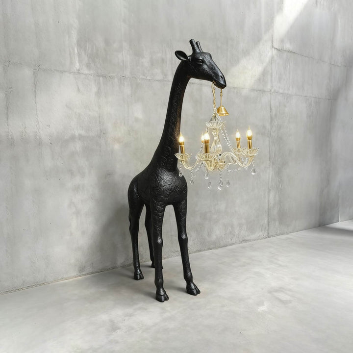 Black resin giraffe floor lamp holding a gold and crystal chandelier