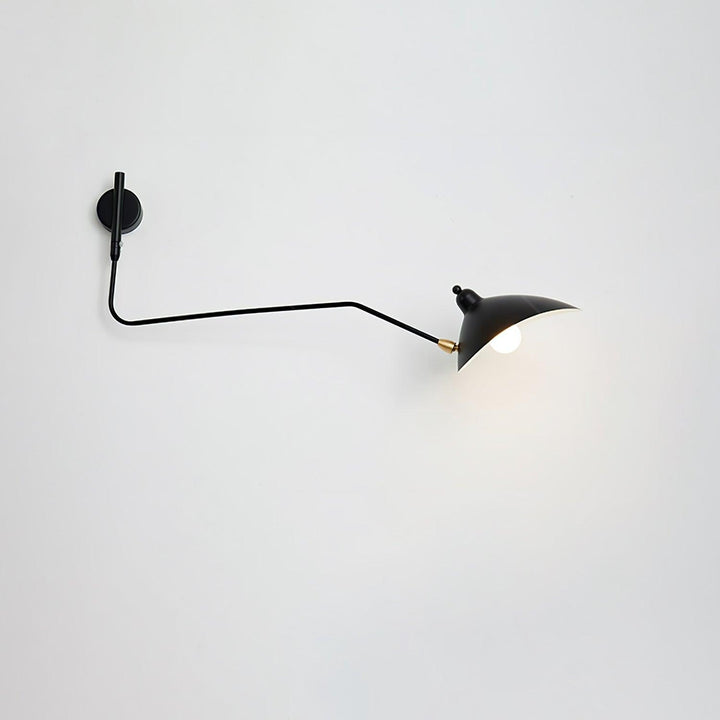 Black single-head adjustable wall sconce casting focused light on a white wall