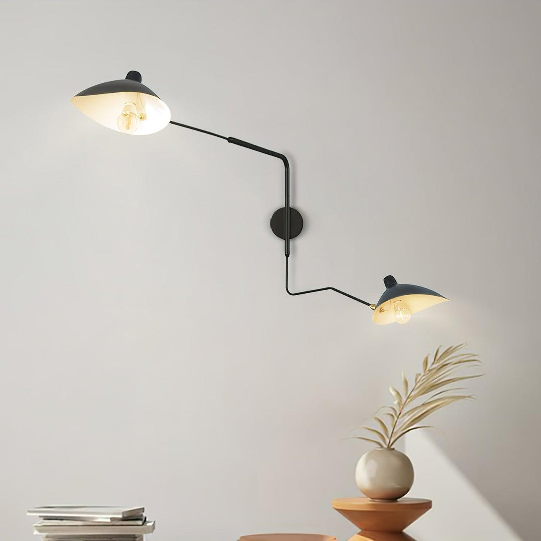 Black two-light wall lamp with adjustable cone shades, long arms and brass joints