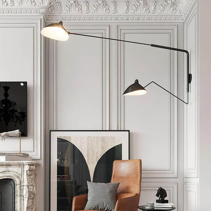 Large black two-light swing arm wall sconce in a paneled classic interior