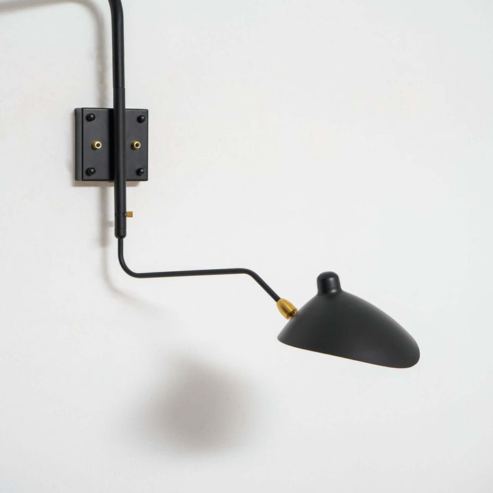 Close-up of the black metal wall sconce arm, square mounting plate and adjustable shade