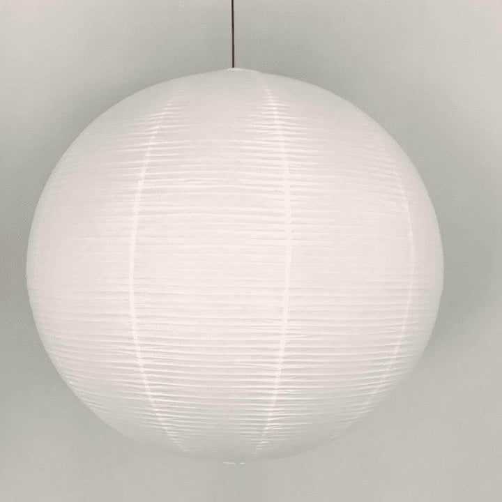 Close front view of a round rice paper pendant light with a black wire