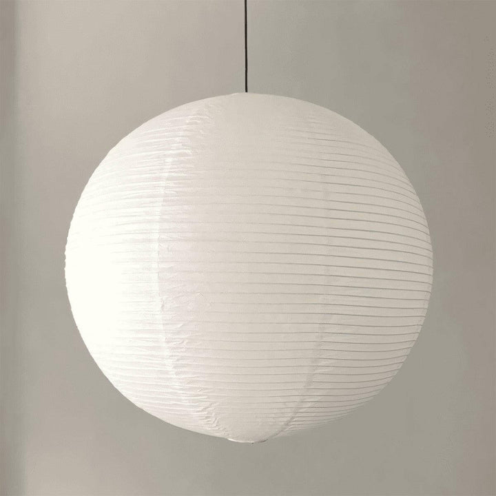 White round paper lantern pendant shown from the side with a black wire