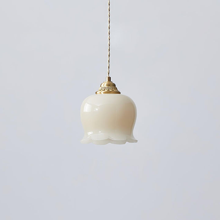 Brass and beige flower pendant light with a smooth resin shade and twisted cord, shown unlit