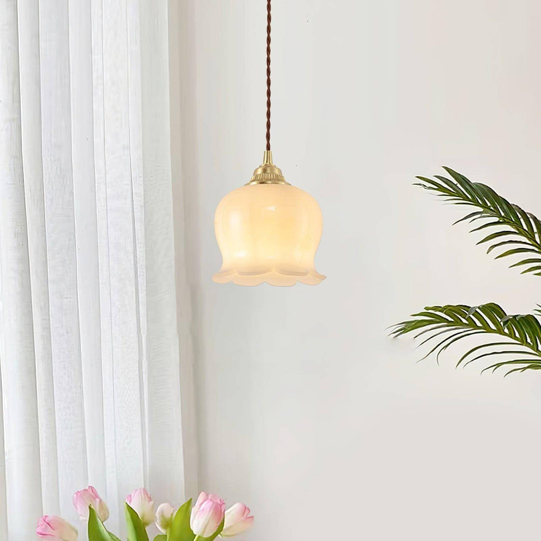 Brass flower pendant light adding warm ambient lighting to a bright room with plants and soft curtains