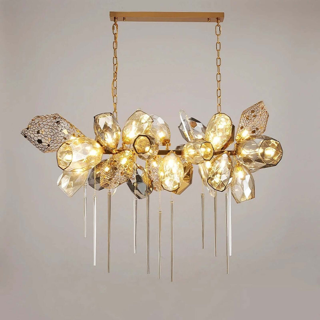 Front view of the horizontal Britannica chandelier with a gold-tone frame and illuminated faceted glass.