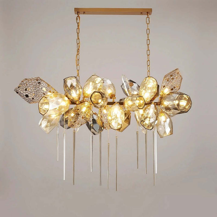 Front view of the horizontal Britannica chandelier with a gold-tone frame and illuminated faceted glass.